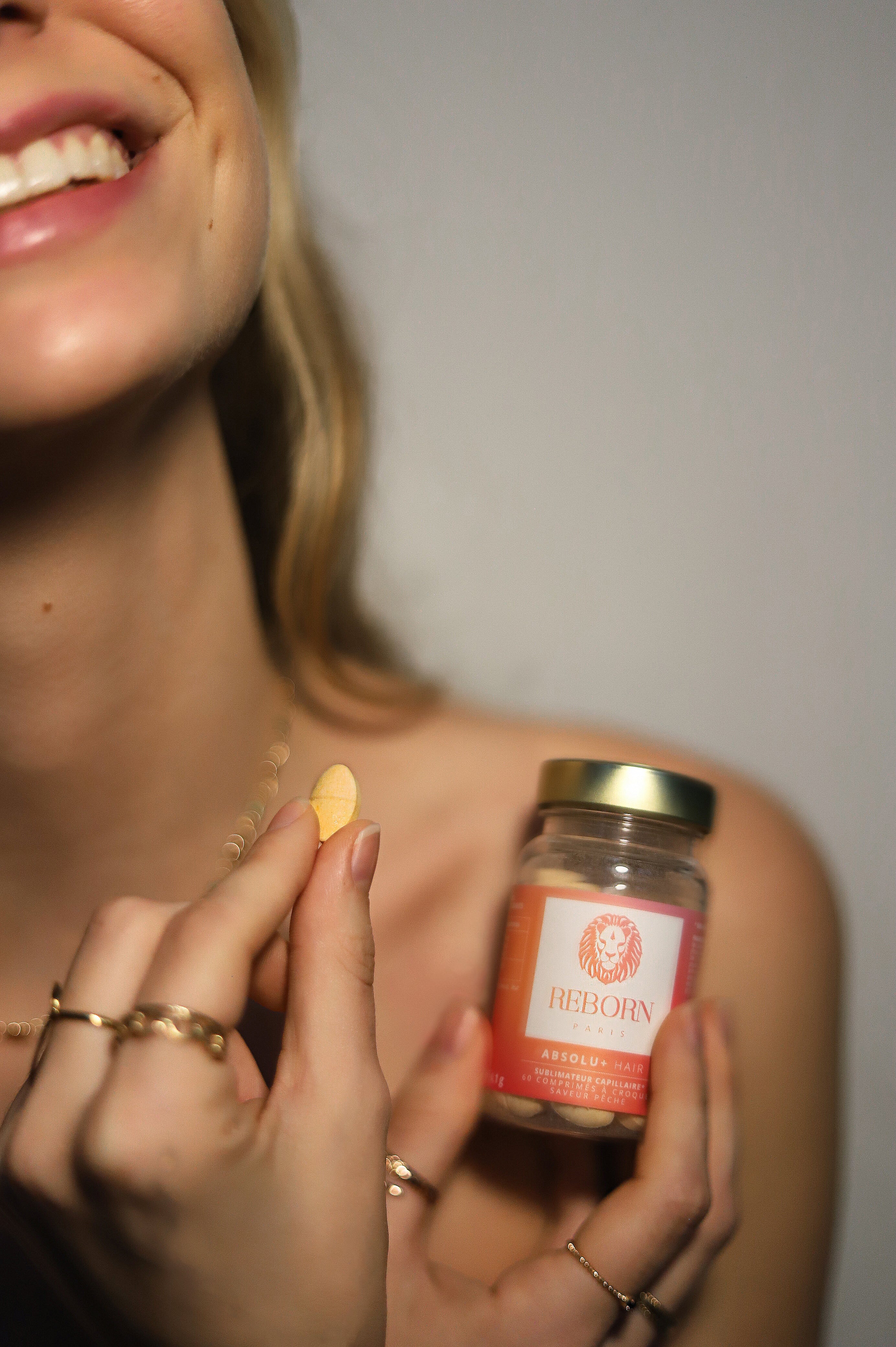 femme tenant un comprimé à croquer à la kératine végétale dans sa main